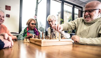 Eine Gruppe älterer Menschen spielt Brettspiele | © adobestock_oneinchpunch_28501728